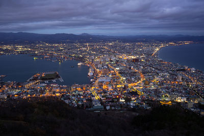 High angle view of illuminated city against sky at night