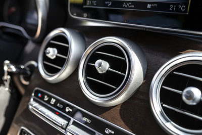 The interior of a modern passenger car with three vents visible and air conditioning control.