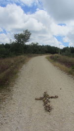 Scenic view of road amidst field against sky