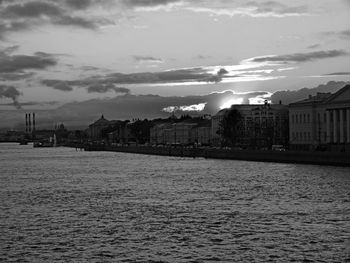 Buildings in city against cloudy sky