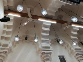 Low angle view of illuminated pendant lights hanging from ceiling