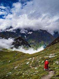 Rear view of person on snowcapped mountain against sky