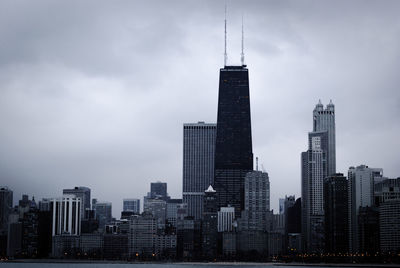 View of skyscrapers against cloudy sky