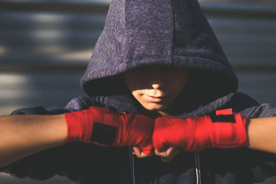 Boy wearing boxing strap while standing outdoors