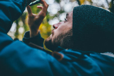 Close-up of bearded man photographing at forest