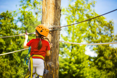 Rear view of girl slacklining in forest