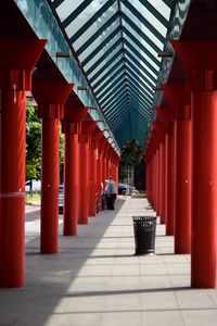 People standing in corridor by red architectural column