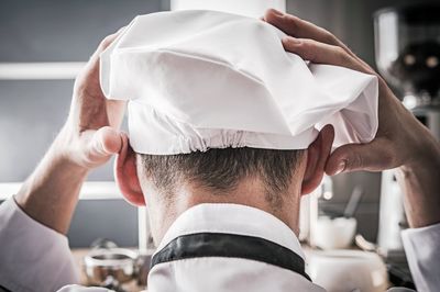 Rear view of chef wearing hat in kitchen