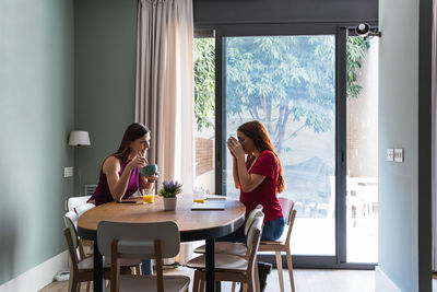 Woman sitting on table at home