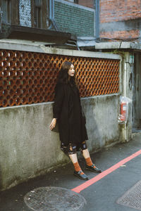 Full length of woman walking on street against building