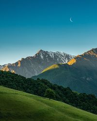 Scenic view of mountains against clear blue sky