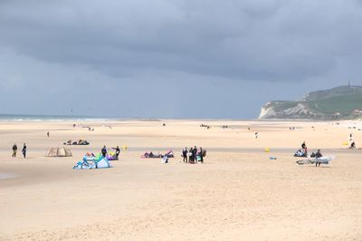 People enjoying at beach against sky