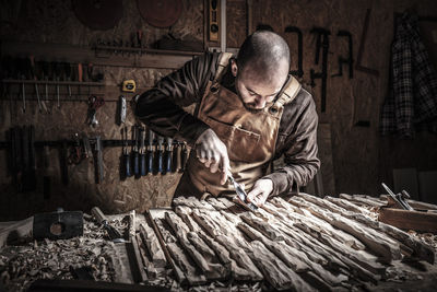 Man carving wood on table at workshop