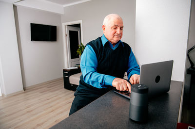 Senior man using laptop at home