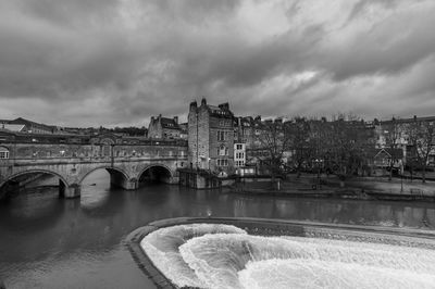 Arch bridge over river against sky