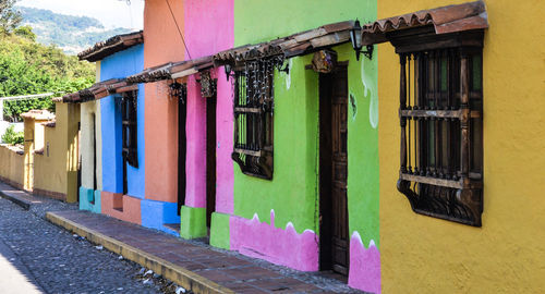 Multi colored umbrellas hanging on street by building