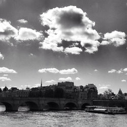 Bridge over river against cloudy sky