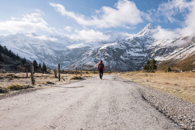 Rear view of man walking on road