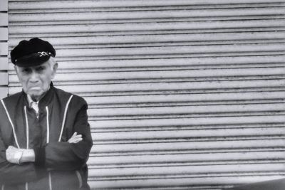 Portrait of young man standing against shutter