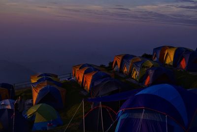 Tent by sea against sky at sunset