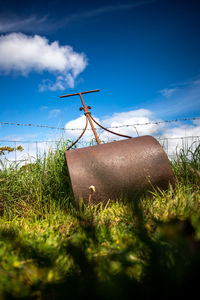 Surface level of grass on field against sky