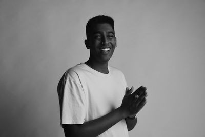 Portrait of smiling young man against white background