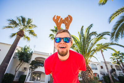 Portrait of young man wearing sunglasses against sky