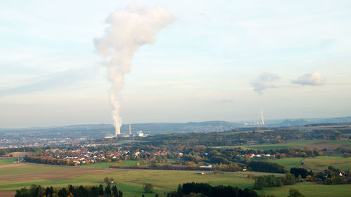 Smoke emitting from chimney against sky