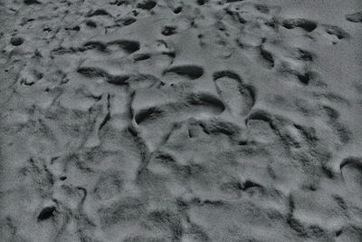 High angle view of footprints on sand at beach during winter