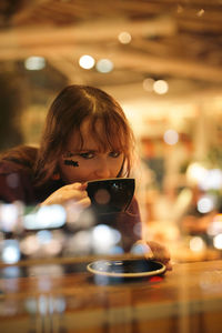 Portrait of smiling young woman sitting on table