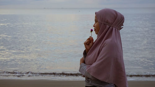 Midsection of woman standing at beach