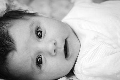 Close-up portrait of cute baby lying on bed