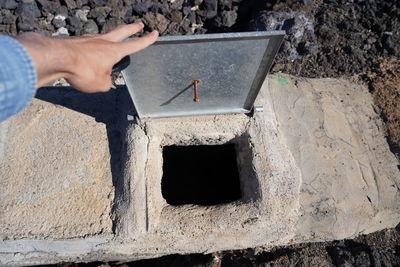 Midsection of man holding hole in concrete wall