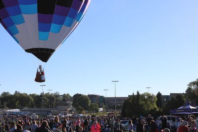 People on hot air balloon against clear sky