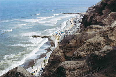 Scenic view of sea by cliff against sky