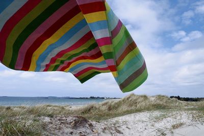 Scenic view of beach with towel against sky