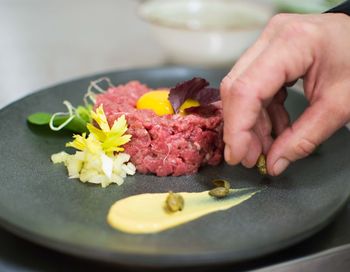 Close-up of person preparing food in plate