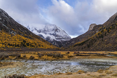 Scenic view of lake by mountains against sky