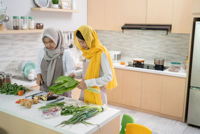 Midsection of woman standing by food at home