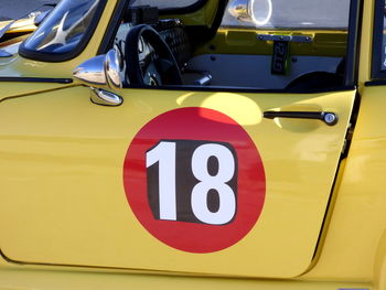 Number 18 on door of yellow sports car