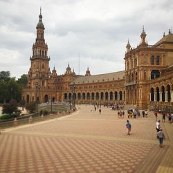 Group of people in historic building against sky