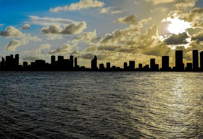 Sea by buildings against sky in city