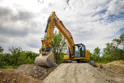 A stopping yellow excavator for rest, at a construction site