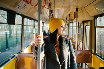 Young woman looking through tram window