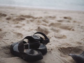 Close-up of shoes on beach