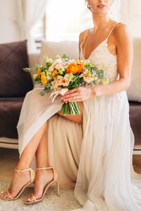 Midsection of woman with bouquet