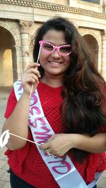 Portrait of smiling young woman wearing bridesmaid sash at vardhman fantasy amusement park