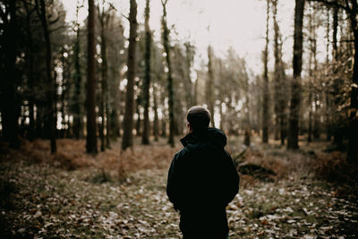 Rear view of man standing in forest