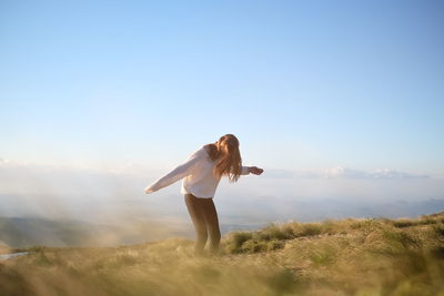 Woman on grassy field against sky