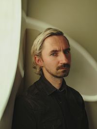 Portrait of young man looking away at home